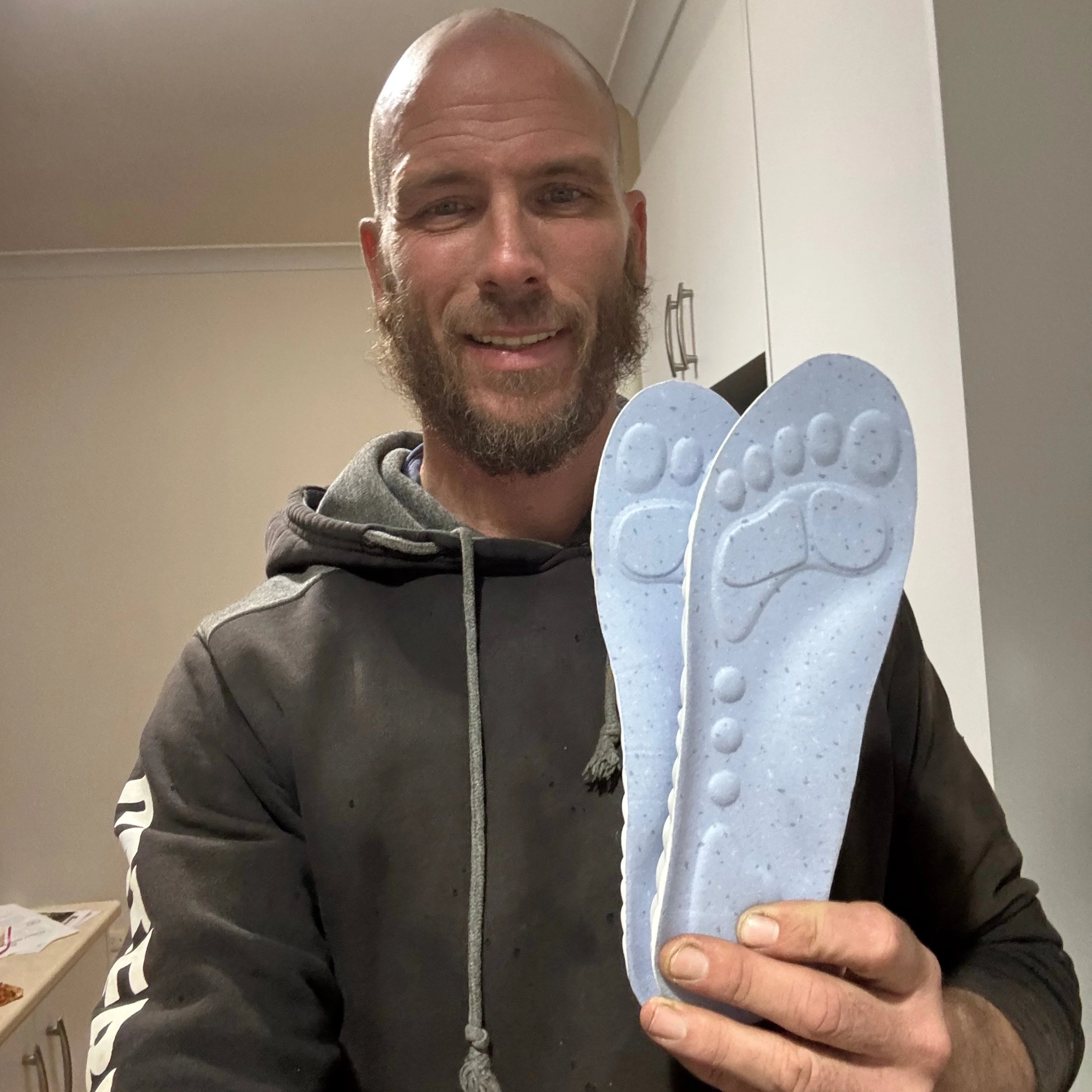 Customer holding SoleBrace WorkFit insoles