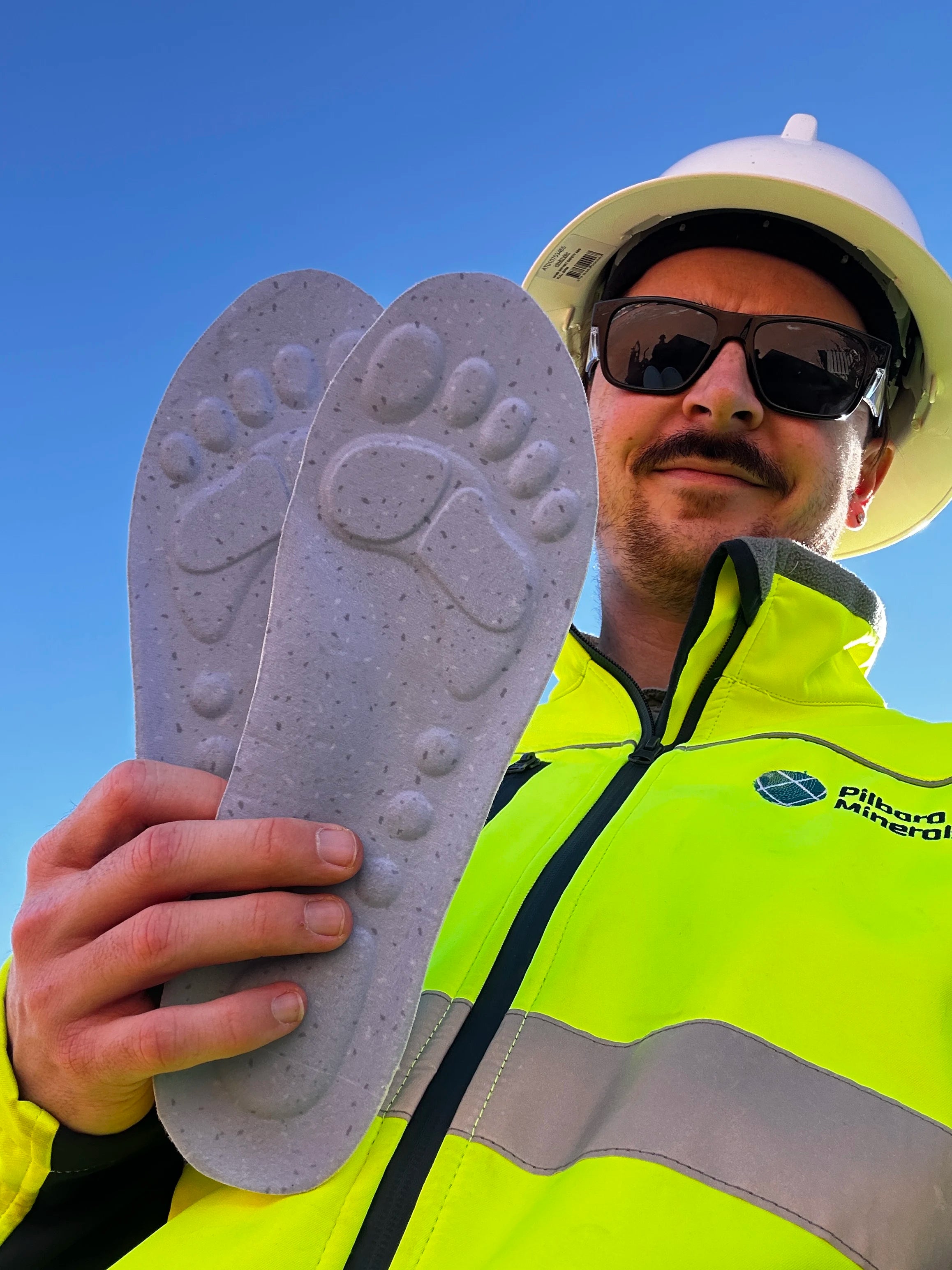 Worker holding the underside of WorkFit Insoles at a mine site